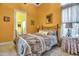 Cozy bedroom with ceiling fan and yellow walls adjacent to a bathroom, featuring a comfortable bed and side tables at 12012 Legacy Estates Blvd, Sarasota, FL 34238