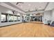 Open and airy gym featuring hardwood floors, a wall of windows, ceiling fans, and mirrored walls at 12012 Legacy Estates Blvd, Sarasota, FL 34238