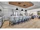Modern kitchen with gray cabinets, a large island, and a wooden ceiling accent in an open floor plan at 12012 Legacy Estates Blvd, Sarasota, FL 34238