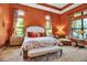 Spacious bedroom with a cozy seating area, tray ceiling, and natural light from large windows at 12012 Legacy Estates Blvd, Sarasota, FL 34238
