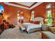 Serene bedroom with a plush bed, tray ceiling, and comfortable lounge area with a TV at 12012 Legacy Estates Blvd, Sarasota, FL 34238