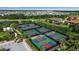 Aerial view of the community tennis and pickleball courts by a pond with parking at 12012 Legacy Estates Blvd, Sarasota, FL 34238
