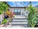 Inviting screened back patio features a spa with steps, an anchor, and tropical plants at 12291 Myrtle Bay Ct, Sarasota, FL 34238