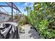 Backyard space with wooden deck and privacy landscaping including mature shrubs and flower pots and grill at 12291 Myrtle Bay Ct, Sarasota, FL 34238
