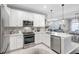 Well-lit kitchen featuring white cabinets, stainless steel appliances, and stone countertops at 12291 Myrtle Bay Ct, Sarasota, FL 34238
