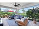 Inviting screened lanai with comfortable seating, ceiling fan, and views of the lush landscaping at 12291 Myrtle Bay Ct, Sarasota, FL 34238