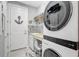 Clean laundry room with front load washer and dryer, sink, and tile backsplash at 12291 Myrtle Bay Ct, Sarasota, FL 34238