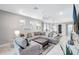 Bright living room featuring a large sectional sofa, a ceiling fan, and natural light at 12291 Myrtle Bay Ct, Sarasota, FL 34238