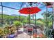Covered patio area with dining table and chairs, surrounded by lush landscaping at 12291 Myrtle Bay Ct, Sarasota, FL 34238