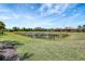 View of a serene pond surrounded by lush green grass at 12291 Myrtle Bay Ct, Sarasota, FL 34238