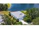 Beautiful aerial view of a house adjacent to a serene lake, with a screened-in pool and ample trees at 12339 Hollybush Ter, Lakewood Ranch, FL 34202