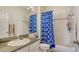 Bright bathroom showcasing granite countertops, a single sink vanity, and a shower with blue curtain at 12339 Hollybush Ter, Lakewood Ranch, FL 34202