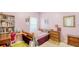Bedroom with light pink walls and neutral carpet featuring a desk, shelving, and dresser at 12339 Hollybush Ter, Lakewood Ranch, FL 34202