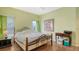 Bright bedroom featuring an iron bed frame, hardwood floors, and plenty of natural light at 12339 Hollybush Ter, Lakewood Ranch, FL 34202