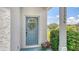Welcoming entrance with a decorated blue door, potted flowers, and a glimpse of the scenic lake view at 12339 Hollybush Ter, Lakewood Ranch, FL 34202