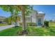 Attractive single-Gathering home showcasing a lush lawn, mature trees, and a welcoming blue front door at 12339 Hollybush Ter, Lakewood Ranch, FL 34202