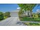 Inviting single-Gathering home with a manicured lawn, mature trees, and a white exterior, enhancing its curb appeal at 12339 Hollybush Ter, Lakewood Ranch, FL 34202