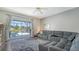 Living room with a gray sectional, patterned rug, and sliding glass doors leading to the pool area at 12339 Hollybush Ter, Lakewood Ranch, FL 34202