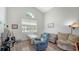 Living room with a vaulted ceiling, and a seating area with a white table by the window at 12339 Hollybush Ter, Lakewood Ranch, FL 34202