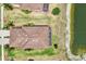 A high-angle view showcases the home's backyard screened-in patio and the proximity to the tranquil pond at 12640 Felice Dr, Venice, FL 34293