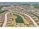 An aerial view shows a community featuring ponds, and well-maintained homes with distinctive red roofs at 12640 Felice Dr, Venice, FL 34293