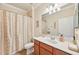 Bright bathroom with vanity, shower curtain, and ample lighting at 12640 Felice Dr, Venice, FL 34293