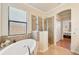 Bathroom featuring a soaking tub, separate shower, and neutral tile work at 12640 Felice Dr, Venice, FL 34293