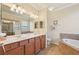 Bright bathroom features dual sinks, soaking tub, and shower at 12640 Felice Dr, Venice, FL 34293