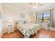 Sunny bedroom with two twin beds, neutral walls, and a ceiling fan at 12640 Felice Dr, Venice, FL 34293