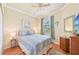 Cozy bedroom with ceiling fan, bedside tables, and window with curtains at 12640 Felice Dr, Venice, FL 34293