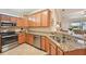 Open-concept kitchen with stainless appliances, granite counters, and light wood cabinets for storage at 12640 Felice Dr, Venice, FL 34293