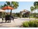 Inviting outdoor seating area featuring comfortable furniture, umbrellas, and beautiful landscaping near lake at 12640 Felice Dr, Venice, FL 34293