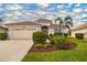 Charming single-story home with a tile roof, lush landscaping, and a well-manicured lawn at 128 Braemar Ave, Venice, FL 34293