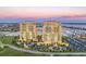 Stunning aerial view of waterfront condos with a private marina, lush landscaping, and elegant architecture at 130 Riviera Dunes Way # 903, Palmetto, FL 34221