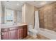 Neutral tiled bathroom with dark wood vanity and shower-tub combo with curtain at 130 Riviera Dunes Way # 903, Palmetto, FL 34221