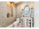 Stylish powder room with decorative wallpaper and mirrored vanity at 130 Riviera Dunes Way # 903, Palmetto, FL 34221