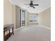 Bedroom with ceiling fan, light walls, and view of city through windows at 130 Riviera Dunes Way # 903, Palmetto, FL 34221