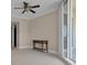 Bright bedroom with ceiling fan, console table, and sliding glass doors to balcony at 130 Riviera Dunes Way # 903, Palmetto, FL 34221