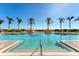 Inviting swimming pool with a clear blue sky, perfect for relaxing and enjoying the serene palm tree view at 130 Riviera Dunes Way # 903, Palmetto, FL 34221