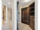 Spacious walk-in closet with custom dark wood shelves and drawers for organization at 130 Riviera Dunes Way # 903, Palmetto, FL 34221