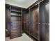 Custom dark wood walk-in closet with built-in shelves and drawers at 130 Riviera Dunes Way # 903, Palmetto, FL 34221