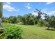Expansive grassy backyard surrounded by mature trees and lush greenery at 13319 Deep Blue Pl, Bradenton, FL 34211