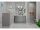 Stylish bathroom with marble floors, glass shower, gray vanity, and modern lighting fixtures at 13319 Deep Blue Pl, Bradenton, FL 34211