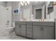 Bathroom featuring double sink vanity, grey cabinets with gold hardware, and marble floors at 13319 Deep Blue Pl, Bradenton, FL 34211