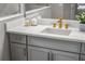 Close-up of a gray bathroom vanity featuring gold hardware and white countertop at 13319 Deep Blue Pl, Bradenton, FL 34211