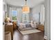 Neutral bedroom with hardwood floors, pendant light fixture, large windows with white curtains, and artwork at 13319 Deep Blue Pl, Bradenton, FL 34211