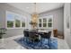 Elegant dining room featuring a modern chandelier, large windows, and a stylish rug at 13319 Deep Blue Pl, Bradenton, FL 34211