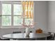Close-up of dining area with a chandelier and centerpiece in front of plantation shutters at 13319 Deep Blue Pl, Bradenton, FL 34211