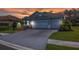 Exterior of light blue two-car garage home with beautiful brick driveway at sunset at 13319 Deep Blue Pl, Bradenton, FL 34211