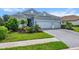 Light blue home with a three-car garage and a beautifully landscaped front yard at 13319 Deep Blue Pl, Bradenton, FL 34211